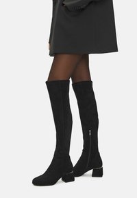Čierne kožené nadkolienkové čižmy z semišu, s robustným opätkom, so zipsom na strane a hladkým povrchom.