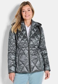 Gevoerde grijze gewatteerde jas met een getailleerde silhoët, ritssluiting aan de voorkant en een capuchon. Bevat diagonale stiksels en zijzakken.