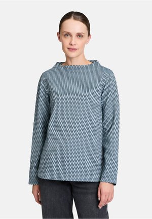 Blå mønstret top med rund halsudskæring, lange ærmer og et struktureret stof med en diamantlignende design.