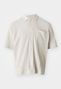 Kortærmet, lysebeige skjorte med krave, vertikal ribbet struktur, fem knapper og en brystlomme.