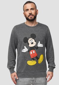Šedá mikina s grafikou Mickey Mouse ve červených šortkách a žlutých botách. Vyrobena z měkkého texturovaného materiálu s žebrováním na manžetách.