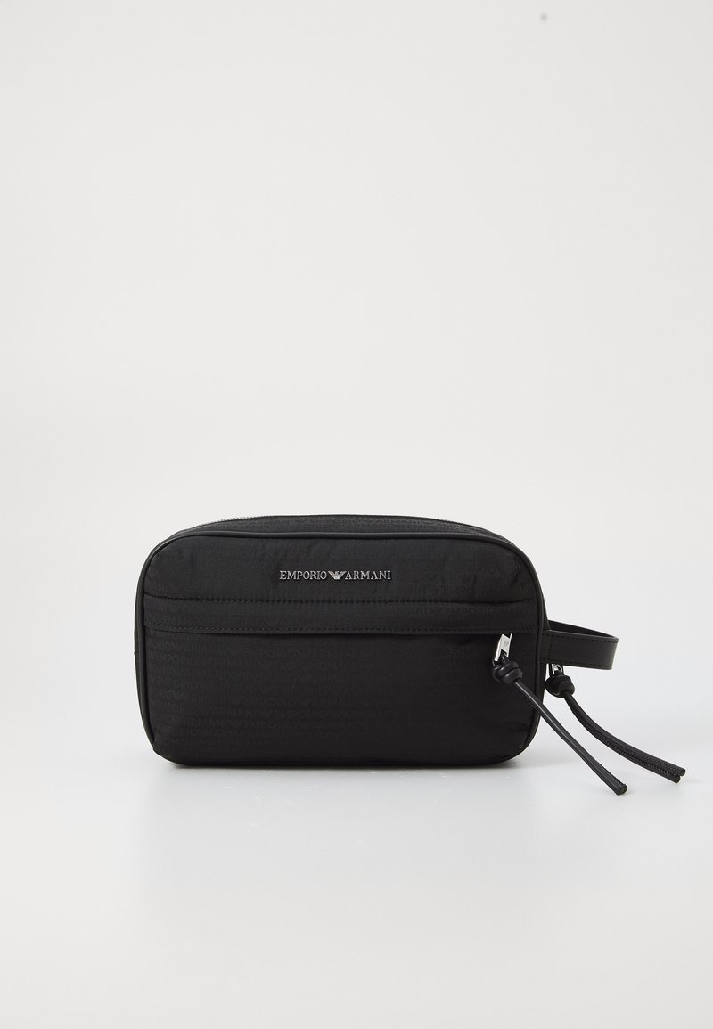 Saco de toilete em nylon preto com fecho de zíper, apresentando um logotipo em relevo, um bolso frontal e detalhes em alça de couro ajustável.