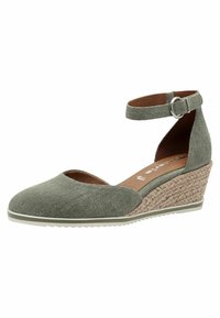 Zapato de cuña de tela verde con correa en el tobillo, punta redondeada, acabado texturizado y acento de yute trenzado. Presenta una suela de goma blanca.