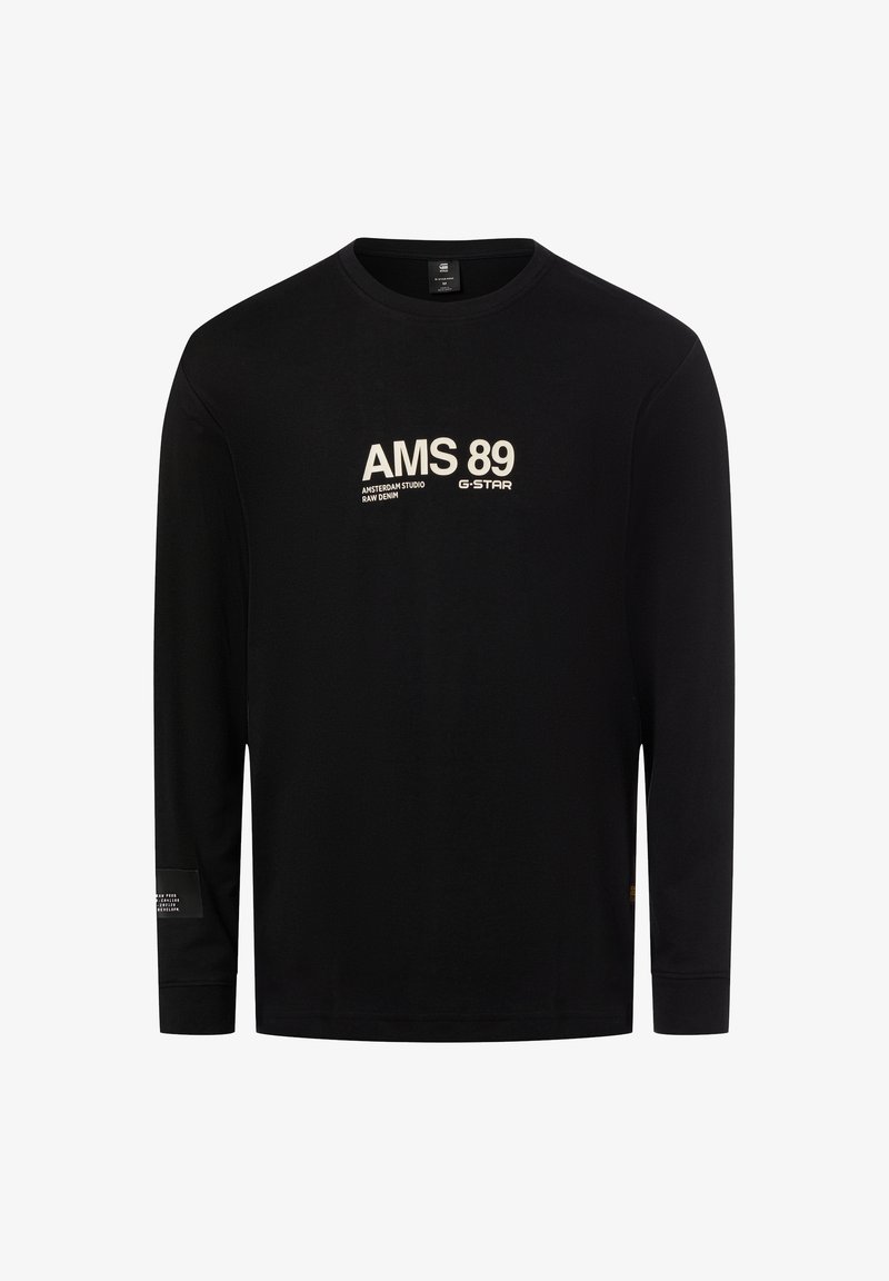 Maglietta nera a maniche lunghe in cotone, con scritta bianca "AMS 89" e logo del marchio. Include un piccolo dettaglio con etichetta sulla manica sinistra.