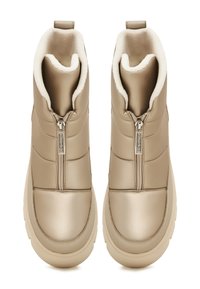 Botas de invierno impermeables en color beige con un diseño acolchado, cremalleras laterales, forro interior de felpa y una suela de goma gruesa para proporcionar tracción.