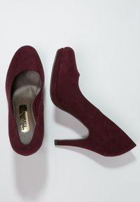 Burgunderfärgade mocka högklackade skor med en slät insida, rund tå och en smal klack, med en subtil plattformdesign.