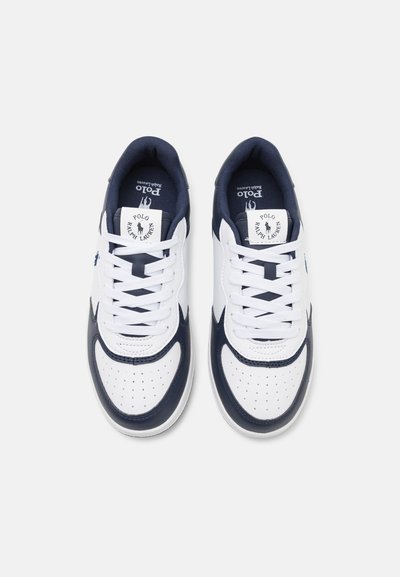Zapatillas deportivas en blanco y azul marino con parte superior de cuero liso, puntera perforada, cordones planos y una etiqueta con el logo en la lengüeta.