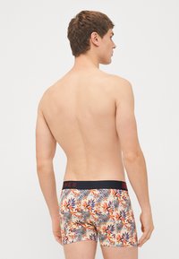 Boxershorts mit Blumen- und Zebramuster und schwarzem Bund. Hergestellt aus elastischem Material, mit lebendigen Farben und einer engen Passform.