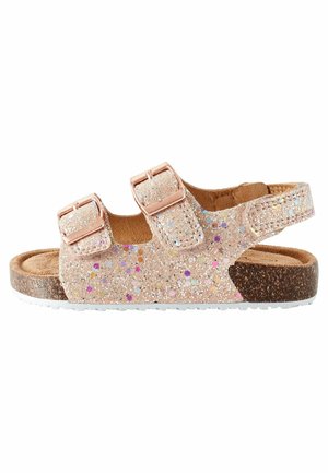 Sandales roses pailletées avec deux boucles réglables, semelle en liège et semelle intérieure texturée. Dotées de paillettes multicolores et d'une semelle extérieure blanche.