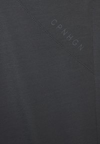 Dark gray fabric with a subtle texture, featuring a diagonal stitching detail and the embossed text "CPNHGN" in a matching tone.