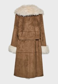 Brun frakke i faux ruskind med en lang silhuet, der har en fluffy cremefarvet faux pelskrave og manchetter samt en bælte i taljen.