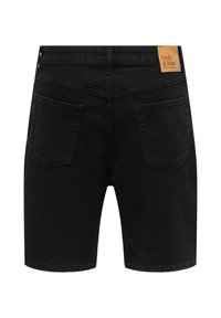 Short en denim noir avec deux poches arrière et une étiquette de marque en cuir fauve sur la ceinture portant l'inscription Only & Sons Denim artisans.