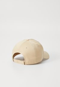 Khaki színű baseball sapka ívelt szélllel, állítható pánttal a hátsó részen és szellőzőlyukakkal a koronán. Sima szövettextúra.