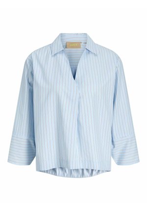 Gaiši zila blūze ar plānām vertikālām sarkanām svītrām, V formas kaklu un trīs ceturtdaļu garuma piedurknēm ar platām aprocēm.