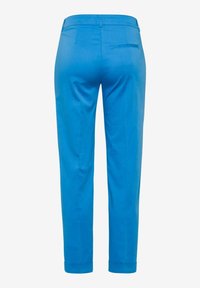 Pantalon bleu taillé sur mesure vu de dos avec une poche passepoilée simple sur le côté droit et une coupe droite et ajustée.