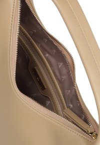 Beżowa skórzana torebka z zamykaną na zamek kieszenią z teksturowanym wykończeniem i wzorem w serca, a także gładkim wnętrzem z minimalną ilością okucia.