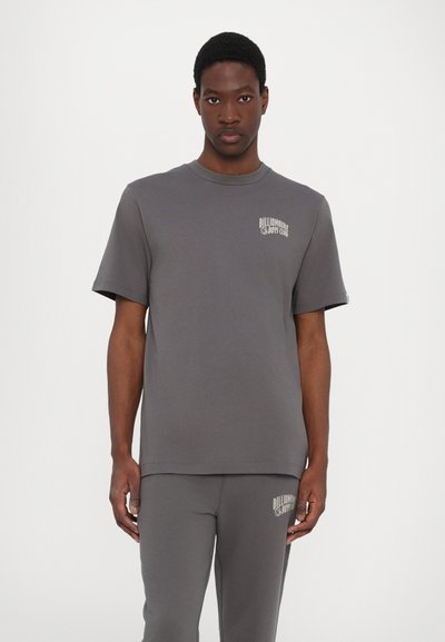 Grijze katoenen t-shirt met korte mouwen en een ronde hals, met een lichtgekleurde logo op de linkerborst. Soepele textuur en losse pasvorm.