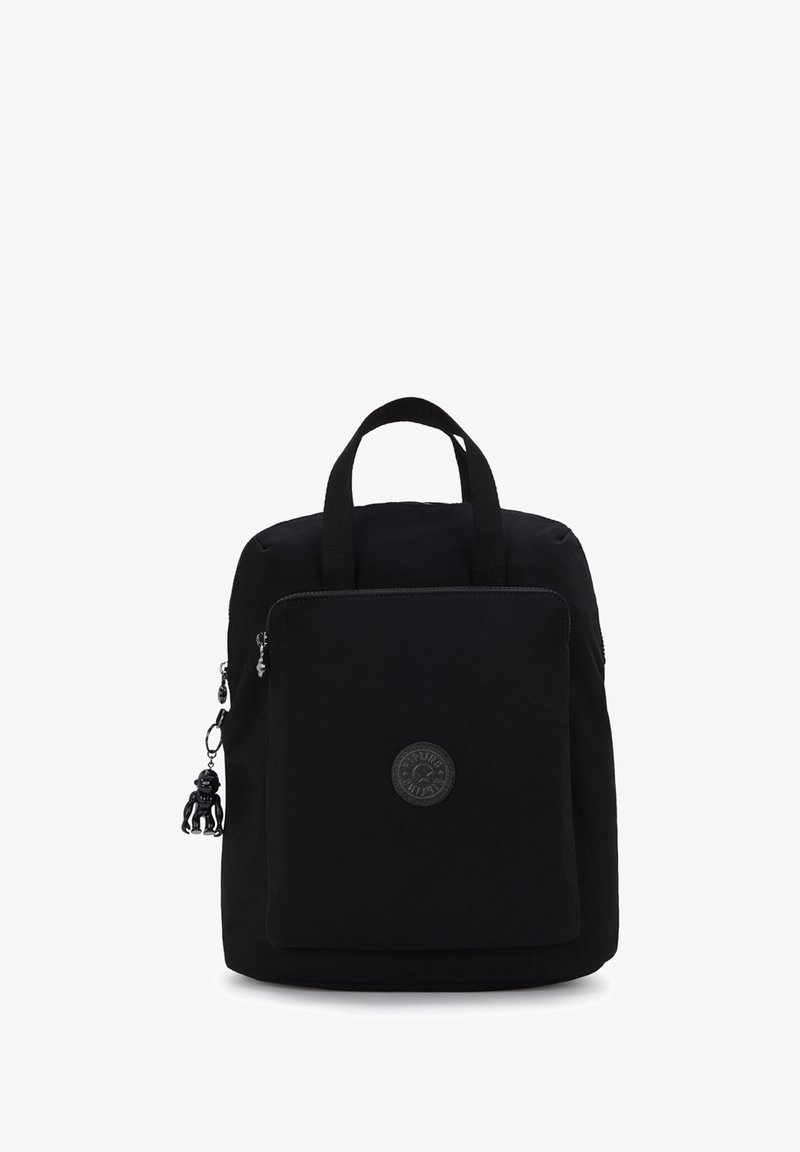 Sac à dos noir en tissu, avec un compartiment principal, une poche zippée à l'avant, un patch logo et un petit charme de singe comme accent.