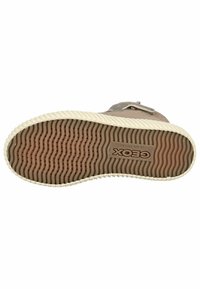 Suela de zapato de goma marrón con un patrón de agarre ondulado, que presenta crestas elevadas y el logo "Geox" incrustado en un acento rectangular.