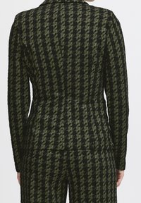 Blazer con motivo pied de poule nero e verde oliva, con spalle strutturate, maniche lunghe e taglio su misura. Tessuto strutturato. Vista posteriore.