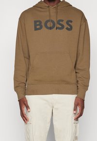 Felpa con cappuccio marrone con un grande logo "BOSS" nero sul davanti, con tasca a marsupio e polsini e orlo a coste.