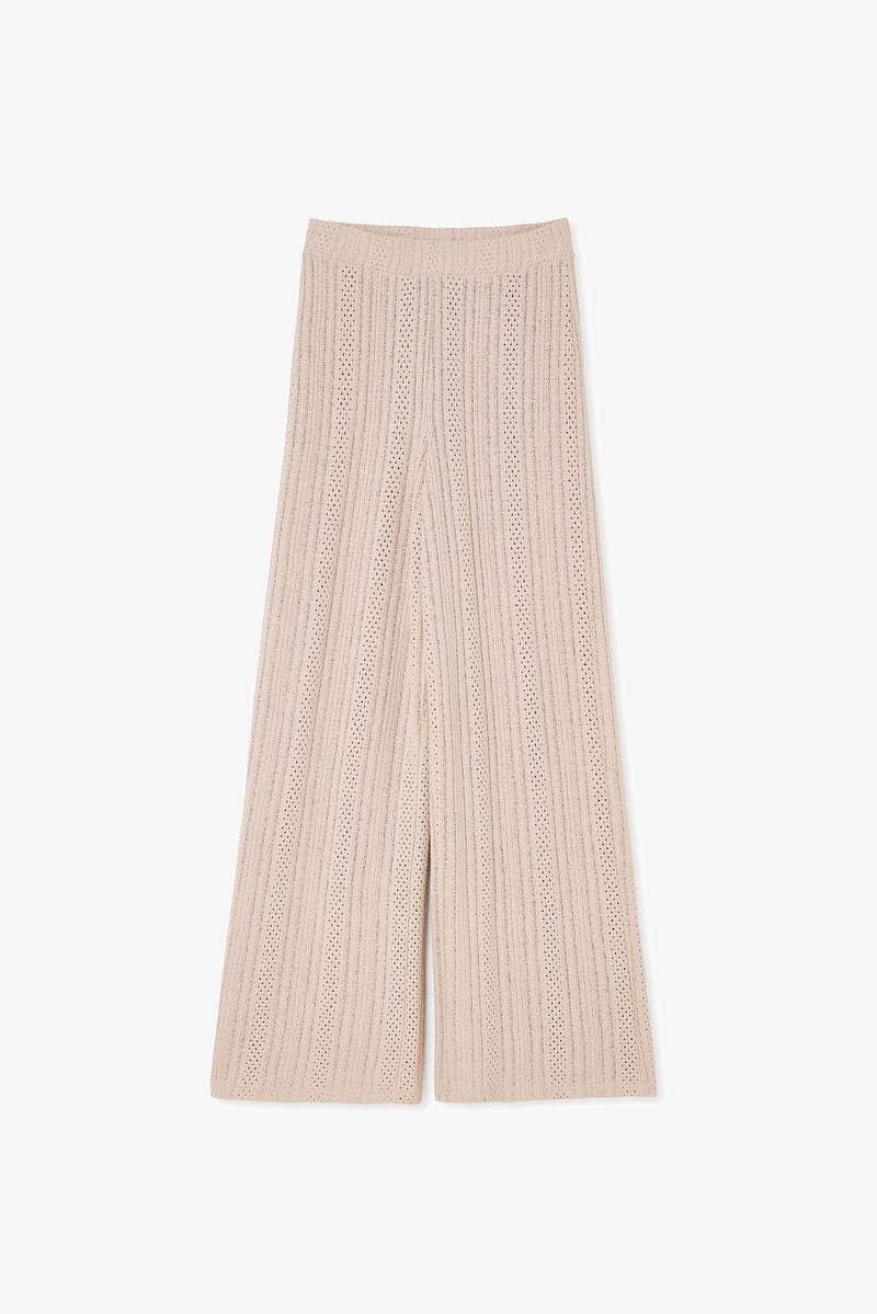 Beige wide-leg knitted pants featuring a ribbed texture with vertical stripes and small cutouts throughout for breathability. Elastic waistband.