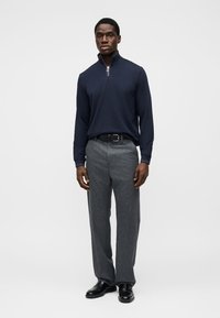 Μπλε ναυτικού μισό φερμουάρ μακρυμάνικο πουκάμισο σε συνδυασμό με γκρι υφασμάτινο παντελόνι και μαύρα παπούτσια. Η εμφάνιση έχει κομψό σχεδιασμό και ραμμένη γραμμή.