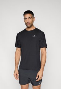 Μαύρο αθλητικό μπλουζάκι με κοντά μανίκια, στρογγυλή λαιμόκοψη και μικρό τριγωνικό λογότυπο στην αριστερή πλευρά. Λείο ύφασμα και εφαρμοστό σχέδιο.