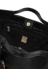 Black leather handbag with a smooth texture, featuring a gold snap closure, zip pocket, and branded interior lining. Rounded shape with two handles.