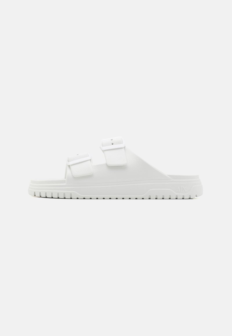 Sandal in gomma bianca con due cinturini regolabili e superficie testurizzata. Presenta una suola spessa con scanalature orizzontali per una migliore aderenza.