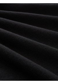 Schwarzer Stoff mit einer strukturierten Oberfläche, die gefaltete Lagen zeigt, die Rippen bilden. Das Material wirkt weich und fest gewebt.