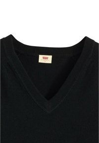 Maglione nero a scollo a V realizzato in morbido materiale a maglia. Presenta un colletto a costine e una sottile etichetta con il logo del marchio, progettato per uno stile aderente.