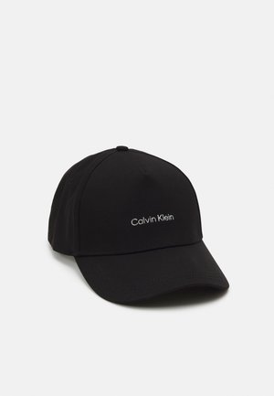 Zwarte baseballpet van stof met een gebogen rand, voorzien van een witte geborduurde "Calvin Klein" logo aan de voorkant.