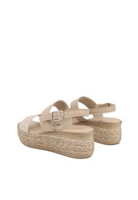 Sandali platform beige con tacco in juta intrecciata, cinturino regolabile con fibbia e una soletta curva e liscia. Accento in tessuto testurizzato sulla punta.