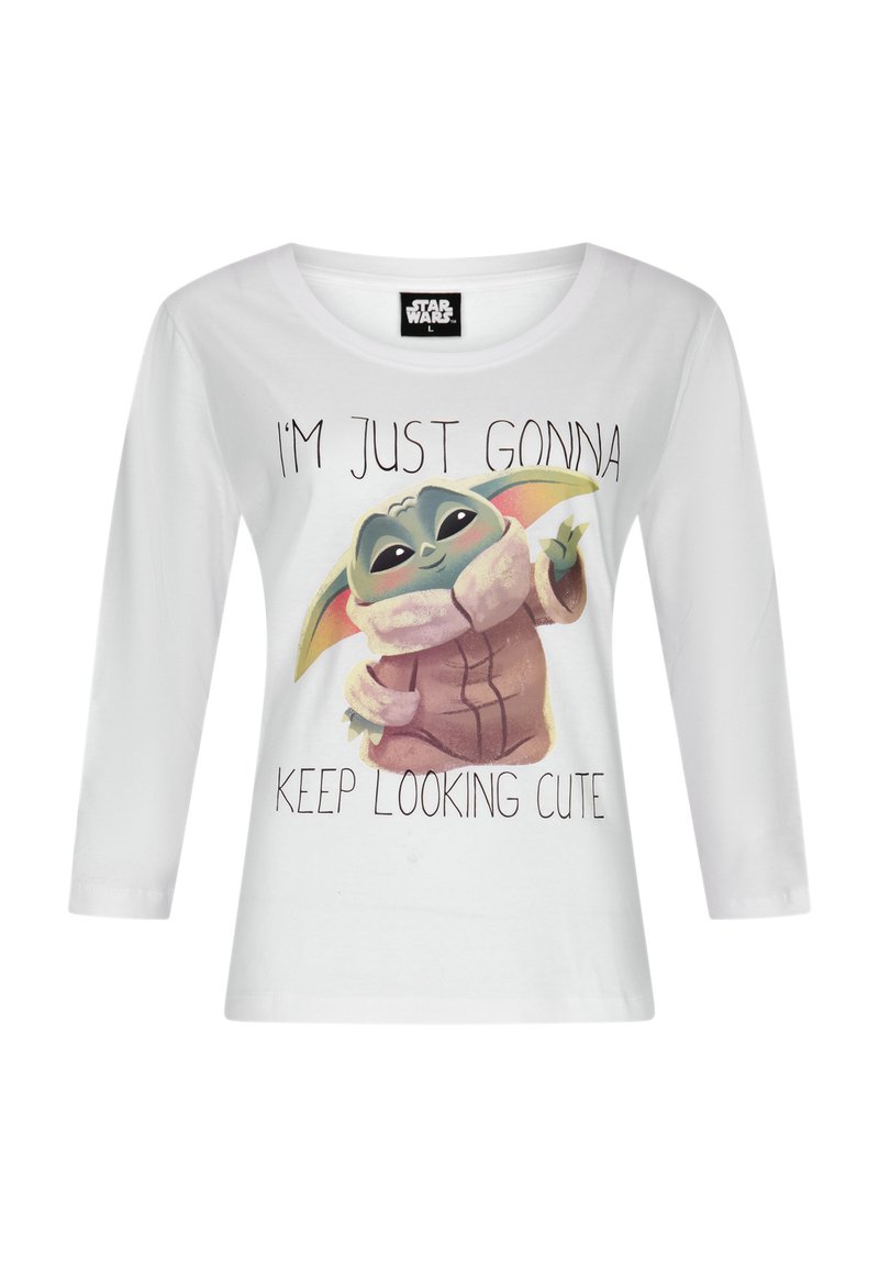 T-shirt bianca a maniche lunghe con una grafica di un personaggio con grandi orecchie, testo che dice "CONTINUERÒ A ESSERE CARINA", e una morbida texture in cotone.