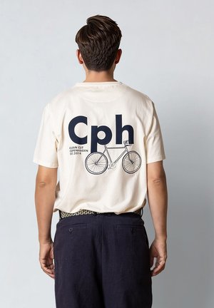 Kremowy bawełniany t-shirt z krótkim rękawem, z dużym nadrukiem "Cph" i konturem roweru na plecach. Gładki przód.