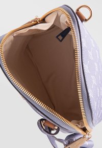 Fioletowa torebka w wzory z złotym zamkiem błyskawicznym, beżową podszewką i małym skórzanym akcentem. Posiada górne zamknięcie na zamek oraz boczną kieszeń.