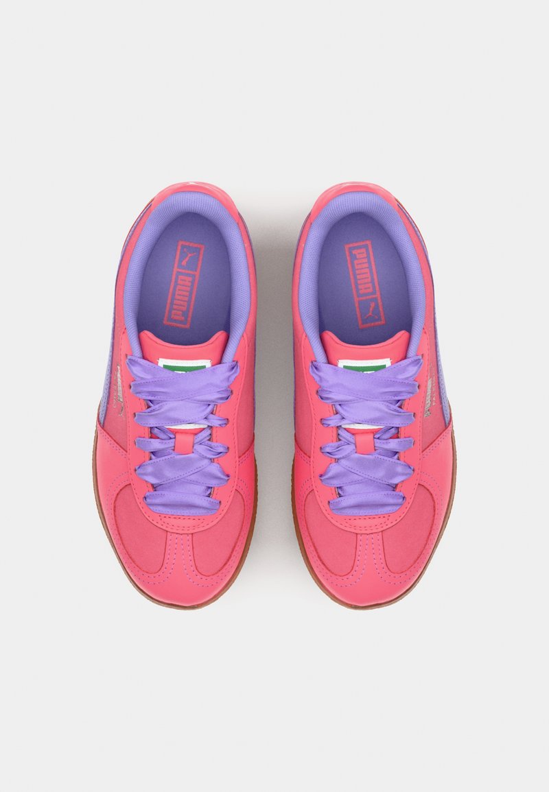 Puma-Sneaker mit einem pinken und lila Design, Obermaterial aus Stoff, lila Schnürsenkel und einer Gummisohle. Mit Logo auf der Zunge.