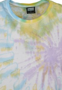 Tie-dye t-shirt med pastelfarver, der har blå, grønne, gule og lavendel cirkulære mønstre på en hvid stof. Ribbet rund hals.