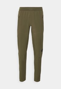 Olivengroene outdoorbroek gemaakt van lichtgewicht stof, voorzien van twee zijzakken met rits en een logo-accent op de linker dij.