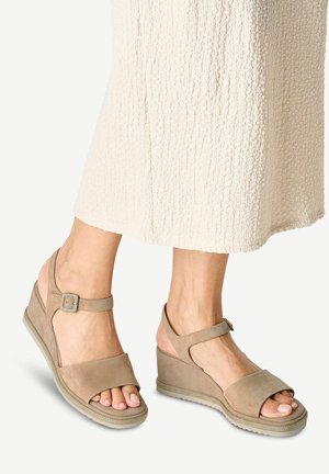 Beige Keilsandalen mit offenem Zehenbereich und verstellbarem Knöchelriemen. Obermaterial aus strukturiertem Wildleder und Gummisohle für guten Halt.