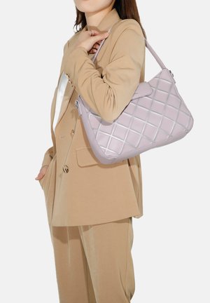 Borsa leggera viola con pattern a rombi e dettagli in argento, portata da una persona in un completo beige, che mette in mostra la sua forma e texture.