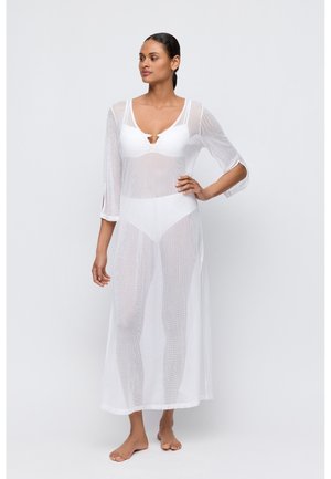 Witte mesh kaftan met driekwart mouwen, met een diepe V-hals en opensneden aan de zijkanten, die een licht gelaagd effect creëren.