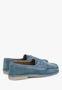 Lichtblauwe suède boten schoenen met twee oogjes, bruine leren binnenzijde en een contrasterende crème rubberen zool, met een moccasin-stijl gestikte neus.