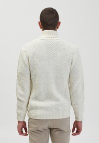 Crème-kleurige gebreide trui met een hoge kraag, textuurpatroon, geribbelde manchetten en zoom, met een ontspannen pasvorm en een klassieke uitstraling.