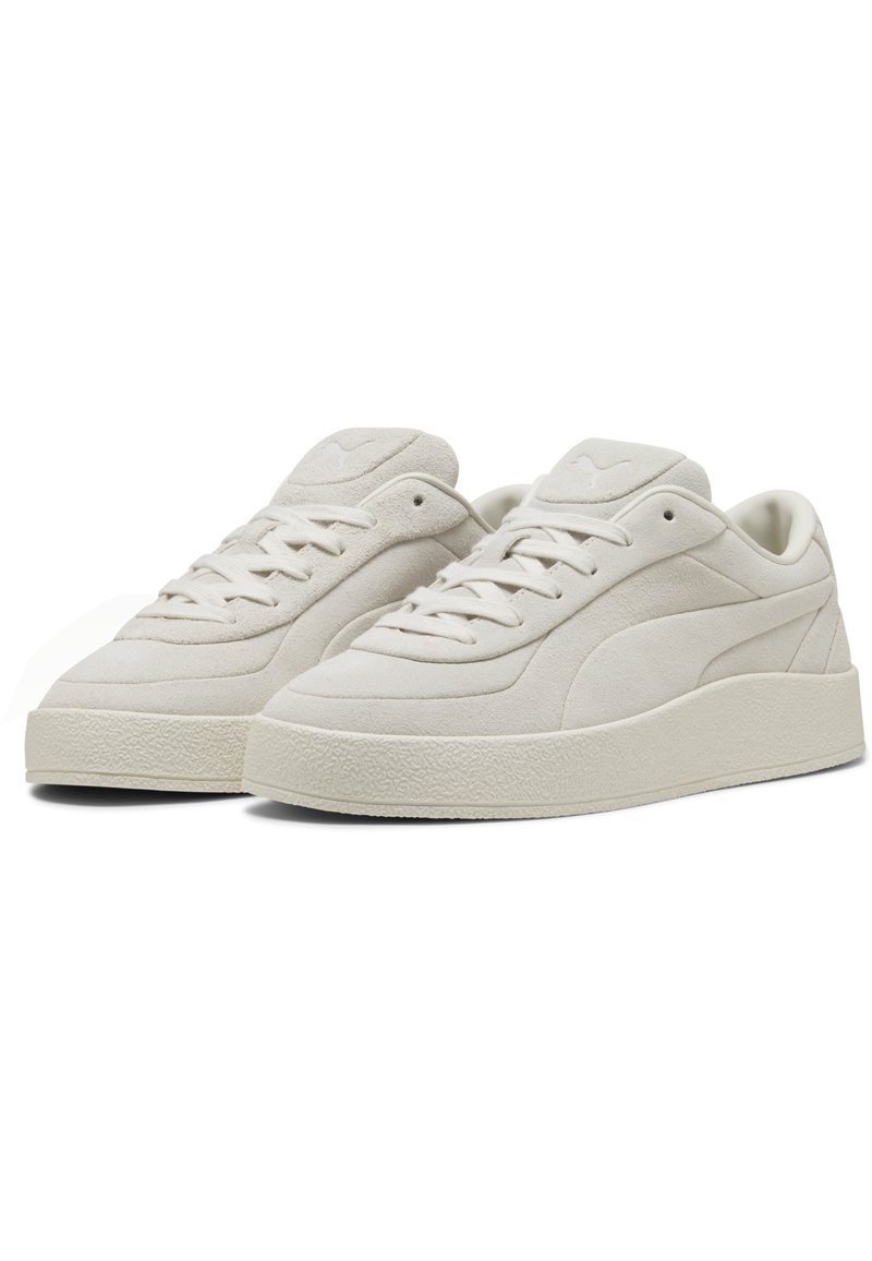 Sneaker in suede bianco con suola in gomma testurizzata, caratterizzati da una punta arrotondata liscia, chiusura con lacci e un logo discreto sulla linguetta.