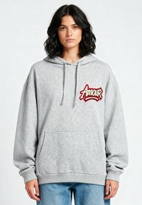Felpa grigia con cappuccio e ricamo "Amour" in rosso e bianco. Presenta una tasca frontale e polsini a coste. Texture morbida e vestibilità oversize.
