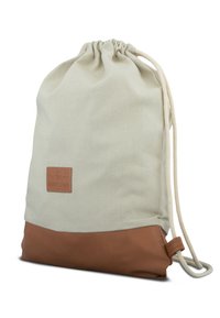 Puuvillainen narureppu, jossa on vaaleanbeige yläosa ja ruskea nahkainen alaosa. Varustettu logopatchilla ja pehmeällä, tekstuurillisella kankaalla.