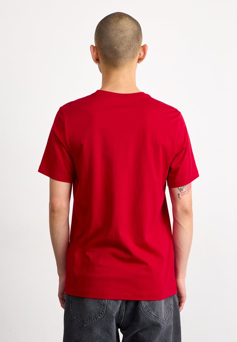 Rotes T-Shirt mit kurzen Ärmeln aus Baumwolle, sportlicher Rundhalsausschnitt und lockere Passform, mit glatter Textur und ohne sichtbare Muster oder Beschläge.