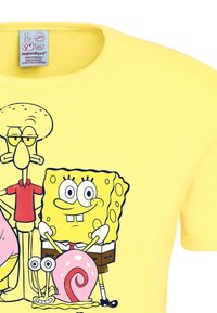 Yellow cotton t-shirt featuring cartoon characters SpongeBob, Squidward, Patrick, and Gary, with vivid illustrations and bold outlines.